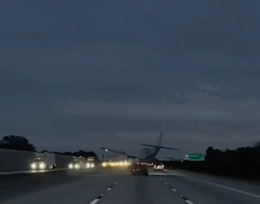 Plane hits car traveling on road.